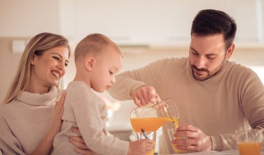 Mutlu aile mutfak portakal suyu içme