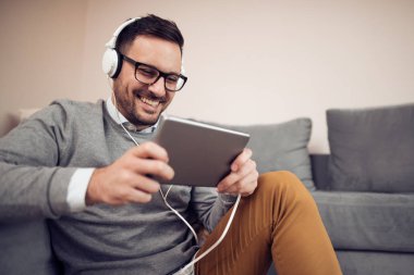 genç adam evde kulaklık ile müzik dinlemek