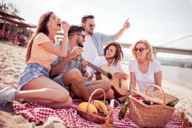 Kumsalda eğleniyor ve soğuk bir bira içme arkadaş.