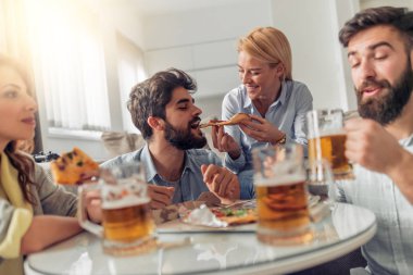 Pizza yiyip evde bira içmeyi gülümseyen arkadaşlar