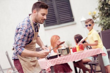 Mutlu genç aile öğle yemeği Barbekü bahçede güneşli günde partisi.