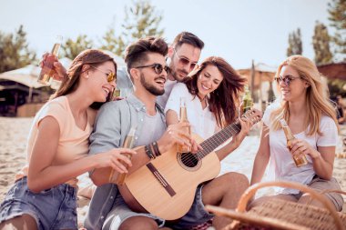 Sahilde gitar çalmak ve soğuk bira içmek arkadaşlar