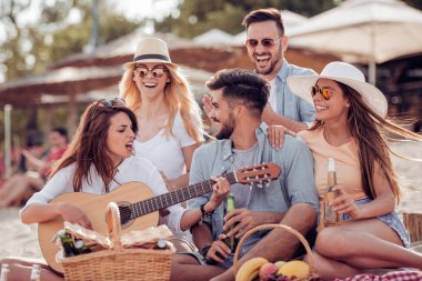 Sahilde gitar çalmak ve soğuk bira içmek arkadaşlar