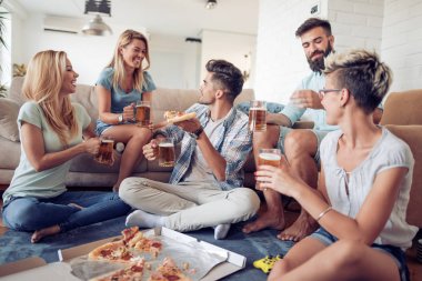 Pizza yiyip evde bira içmeyi mutlu genç arkadaş grubu