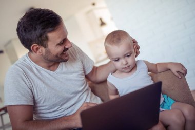 Genç Baba ve küçük oğul evde laptop tarama