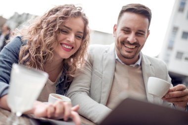 Açık havada eğleniyor ve gülümseyerek, tablet üzerinde seyir mutlu genç Çift.