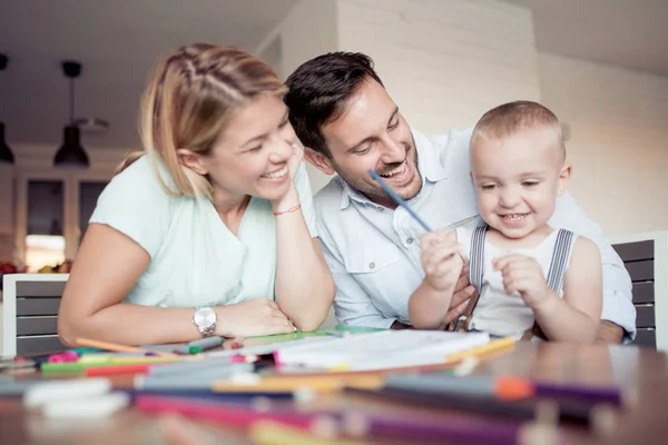 Mom and dad drawing with son at home