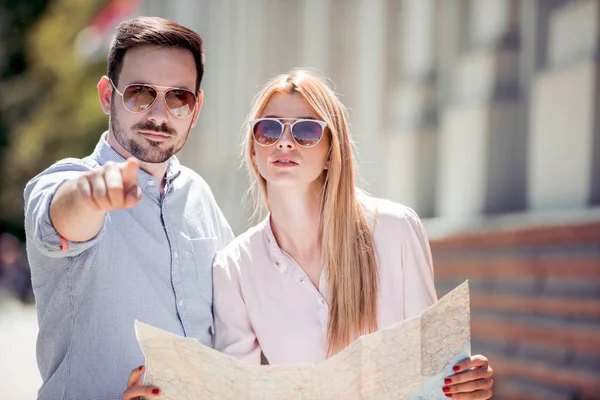 Traveling couple searching for next destination with map