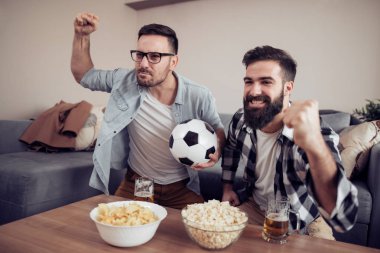 Evde TV'de futbol izlerken iki genç futbol taraftarları