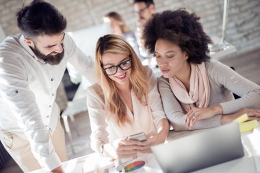 bilgisayarda çalışarak ve fikirler toplantısında tartışırken iş ortakları