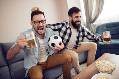 Evde TV'de futbol izlerken iki genç futbol taraftarları