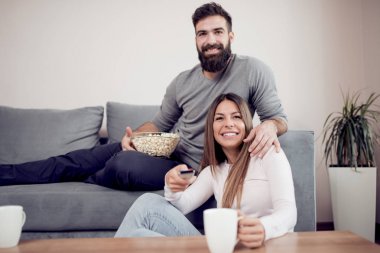 Patlamış mısır yemek ve oturma odasında film izlerken Çift