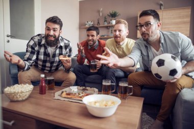 Grup arkadaşları-futbol izlerken futbol oyun televizyon ve kutlama hedefte fanlar