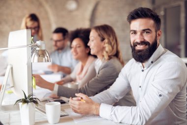 Ofisteki iş adamları bir konferans düzenleyip stratejileri tartışıyor.