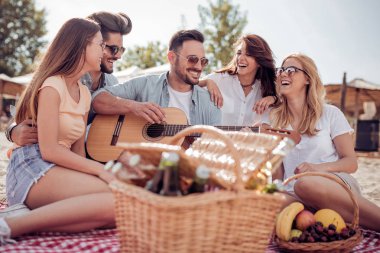 Sahilde gitar çalmak ve soğuk bira içmek arkadaşlar