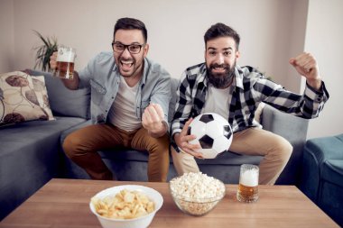 Evde TV'de futbol izlerken iki genç futbol taraftarları