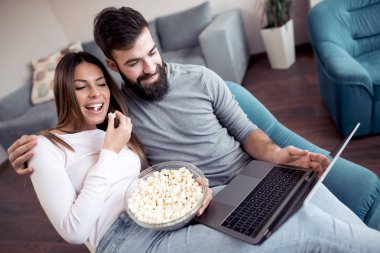 Patlamış mısır yemek ve oturma odasında film izlerken Çift