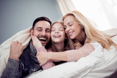 Aile yatak odasında Tv izliyor ve gülüyor 