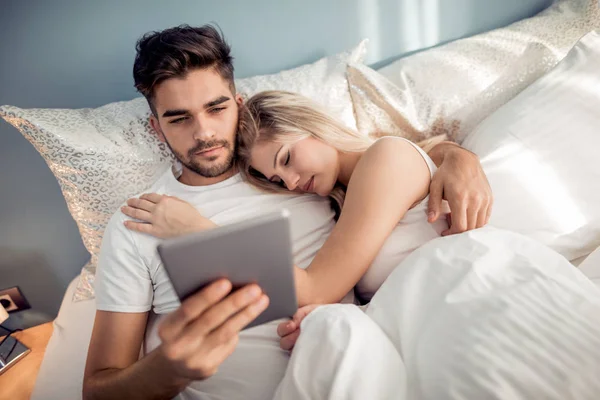 男子躺在床上与妇女和使用平板电脑 — 图库照片