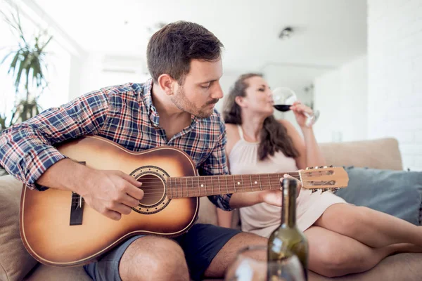Mann Spielt Gitarre Wohnzimmer Frau Hört Und Trinkt Wein — Stockfoto