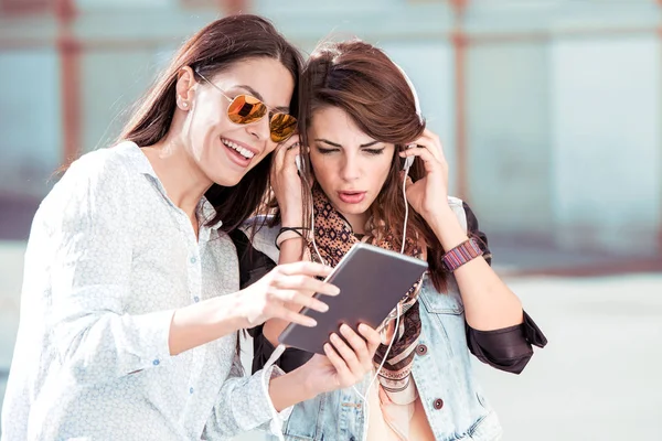 Duas Jovens Mulheres Ouvindo Música Com Tablet — Fotografia de Stock