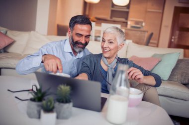 Olgun çift dizüstü evde mutfak kullanma