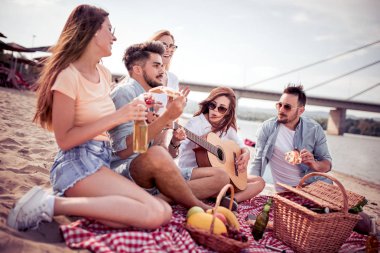 Sahilde gitar ile eğlenmek ve soğuk bira içmek arkadaşlar