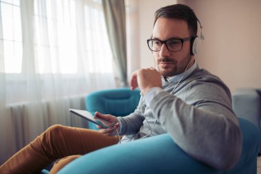 genç adam evde kulaklık ile müzik dinlemek