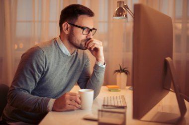 Karanlık odada bilgisayarda çalışan genç adam