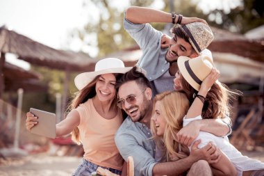 selfie tablet ile kumsalda alarak genç arkadaş grubu