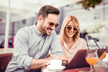 Dizüstü bilgisayar kullanarak ve kafede kahve içme genç Çift