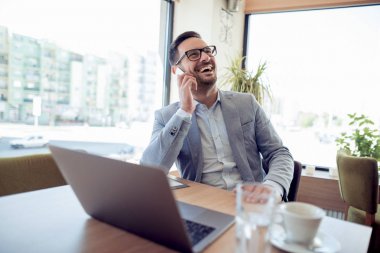 dizüstü bilgisayar kullanan işyerinde rahat gömlekli genç işadamı