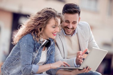 Rahatlatıcı ve şehir sokak dizüstü kullanarak genç Çift