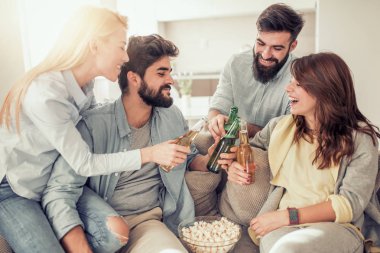 Neşeli grup arkadaşıyla birlikte bira içip patlamış mısır evde yemek