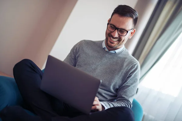 Glimlachend Jonge Man Kijken Werken Laptop Thuis — Stockfoto
