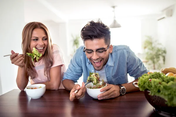 young couple eating healthy salad for breakfast in kitchen