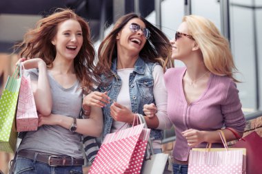 Şehrin alışveriş torbaları ile üç güzel kız. İnsanlar, satış, alışveriş, eğlence ve mutluluk kavramı.