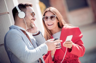 Mutlu genç çift sokakta müzik dinlerken eğleniyor closeup.