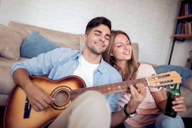 Yakışıklı adam müzik gitar kız arkadaşına oynamak.. 