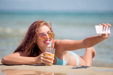 Yaz plaj tatil ve alma selfie fotoğraf akıllı telefon ile zevk kız. 