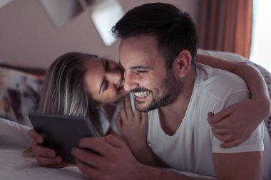 Tablet yatak odasında film izlerken mutlu genç Çift.