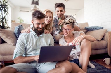 Birlikte kanepede oturan ve eğlenceli izlerken arkadaşlar video üstünde laptop.