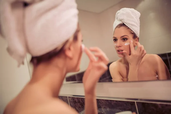 Genç Kadın Banyoda Temiz Yüz Kremi Koyarak — Stok fotoğraf
