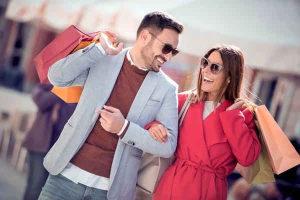 Pareja Cariñosa Llevando Bolsas Compras Hombros Tomándose Mano Mientras Camina —  Fotos de Stock