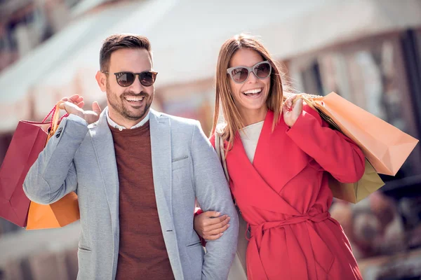 Jong Paar Dragende Boodschappentassen Schouders Liefdevolle Hand Hand Tijdens Een — Stockfoto