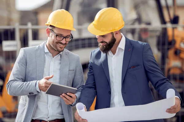 Dwóch Inżynierów Szczęśliwy Przy Użyciu Tabletu Podczas Pracy Budowie — Zdjęcie stockowe