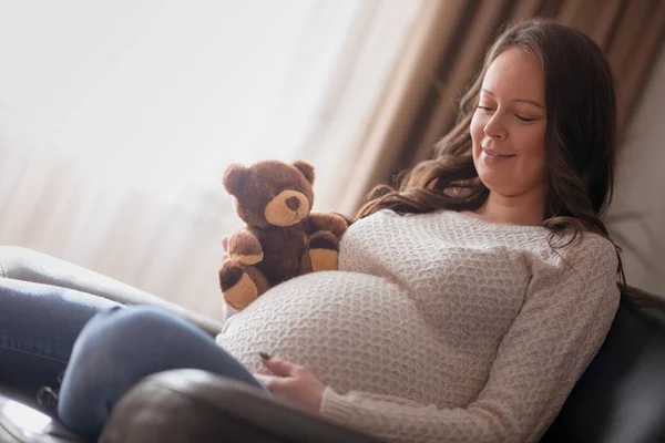Έγκυος Γυναίκα Αρκουδάκι Που Κάθεται Στον Καναπέ Στο Σπίτι — Φωτογραφία Αρχείου