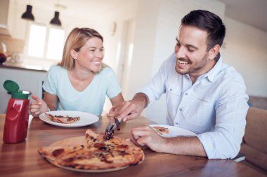 Ev yapımı pizza birlikte yemek çift gülümseyen genç.