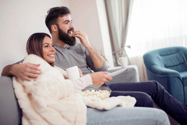 ソファーでテレビを見ていると ポップコーンを食べて幸せなカップル — ストック写真