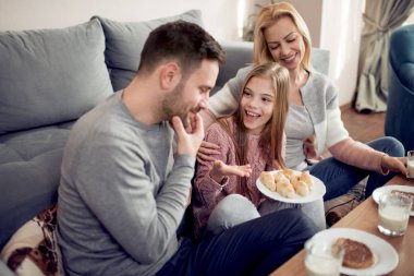Üç sabahları kahvaltı onların ev oturma odasında birlikte olan aile.